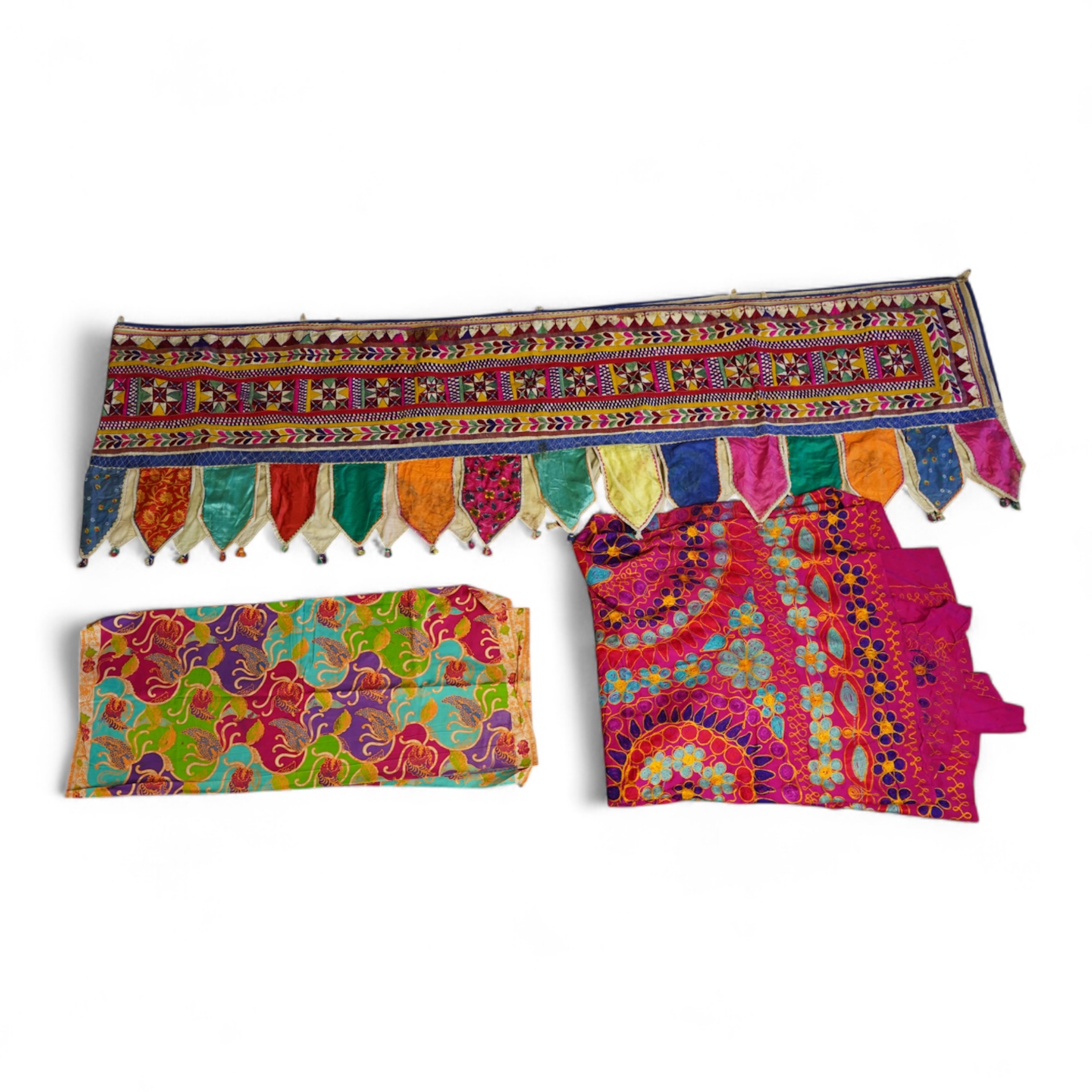 A large Indian silk embroidered and mirrored temple pelmet, with a cerise silk embroidered hanging and a length of cotton wax resist style printed fabric. Temple pelmet 468cm long x 70cm, deep. Condition - the pelmet has